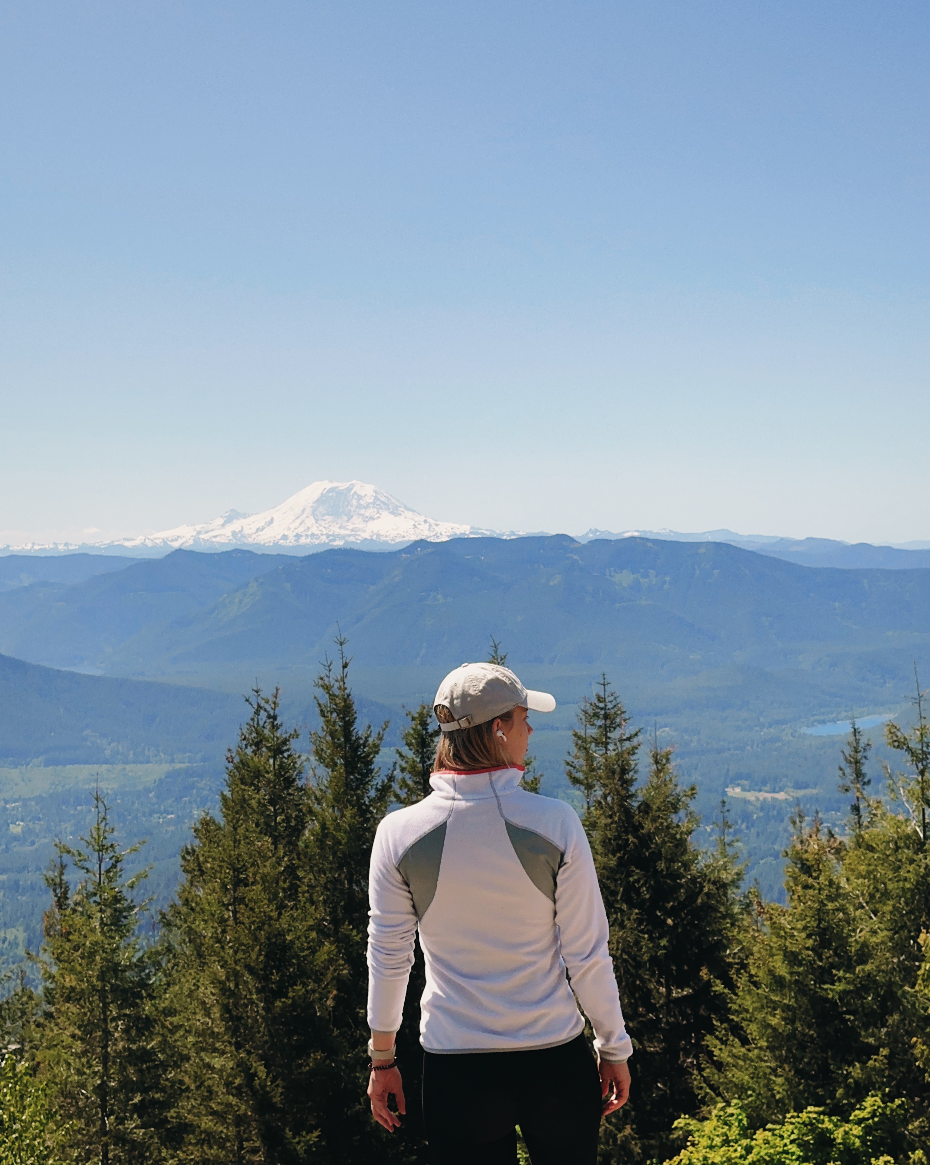 Girl standing facing the big snowy mountain on the background.